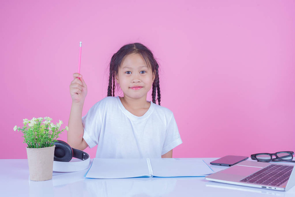 Girls write books on a pink background. - Foto, afbeelding