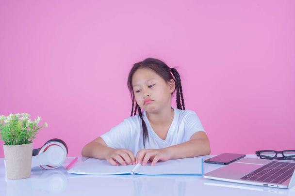 Mädchen schreiben Bücher auf rosa Hintergrund. - Foto, Bild