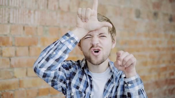 Cheerful Young Man Gesturing Loser Sign - Footage, Video