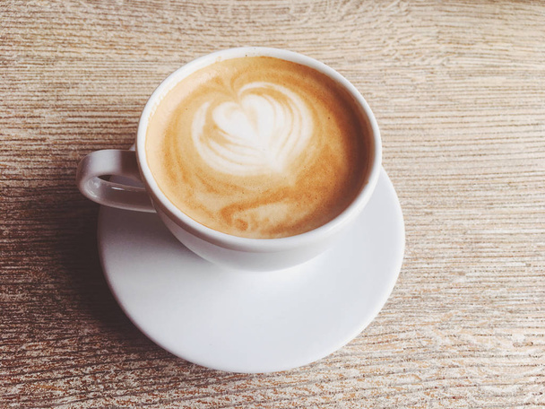 Чашка гарячого капучино в кафетерії, кава на дерев'яному столі
 - Фото, зображення