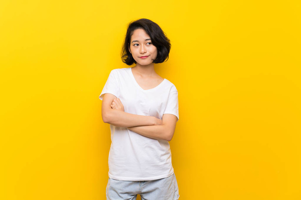 Asian young woman over isolated yellow wall feeling upset - Fotografie, Obrázek