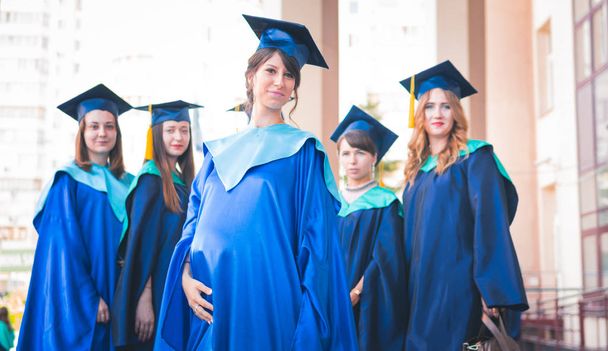 A group of young female graduates. Female graduate is smiling ag - Photo, Image