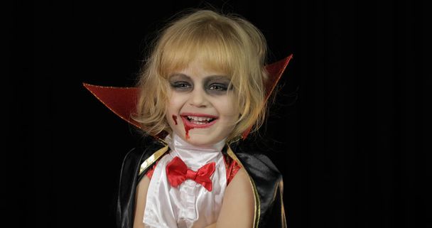 Niño Drácula. Chica con maquillaje de Halloween. Niña vampiro con sangre en la cara
 - Foto, imagen