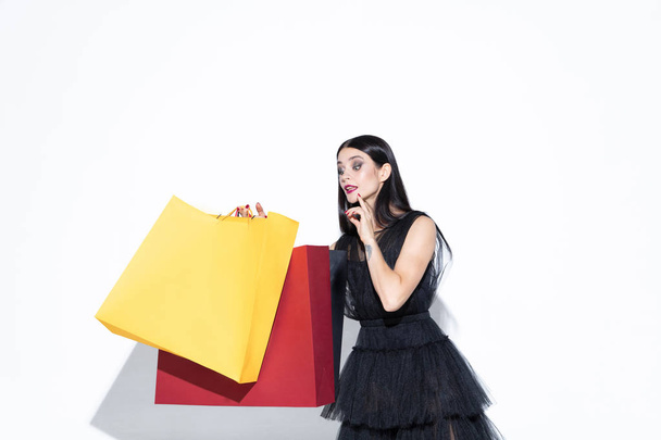 Young woman in dress shopping on white background - 写真・画像