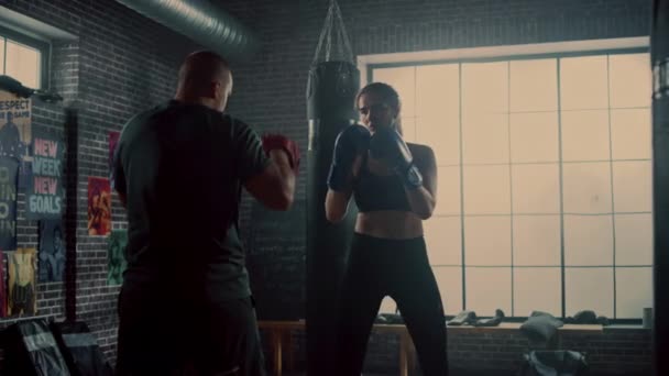 Fit Athletic Woman Kickboxer Punches the Punching Pads During a Workout in Gym. She's Beautiful and Energetic. Coach is Holding the Boxing Pads. Intense Self-Defence Training. They're Happy and Laugh. - Πλάνα, βίντεο