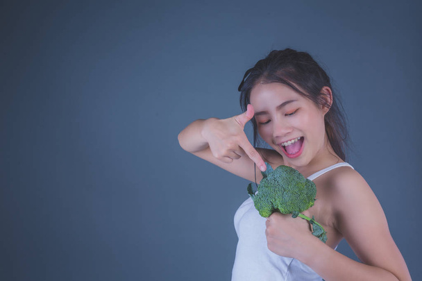 Mädchen hält Gemüse auf grauem Hintergrund. - Foto, Bild