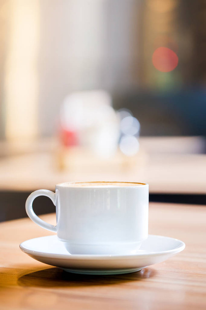 Latte Kahve ahşap masa ve Kahve dükkanı bulanıklık backg bir fincan - Fotoğraf, Görsel