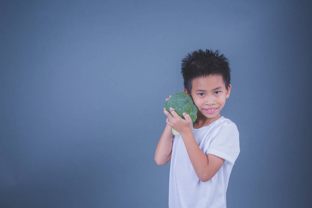 Children holding vegetables on a gray background. - Foto, Bild