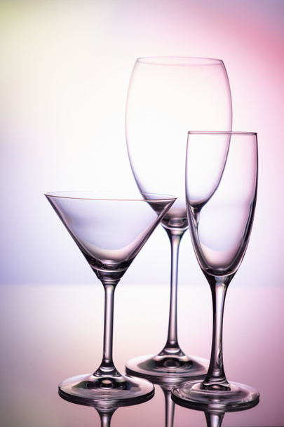 Empty glass goblets set. On a colored purple background abstract - Φωτογραφία, εικόνα