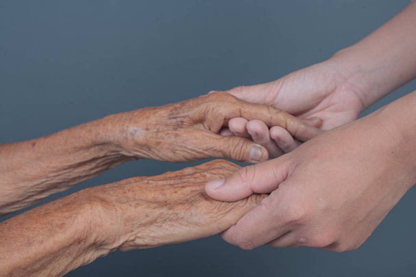 Mujer joven sosteniendo la mano de una anciana. - Foto, Imagen