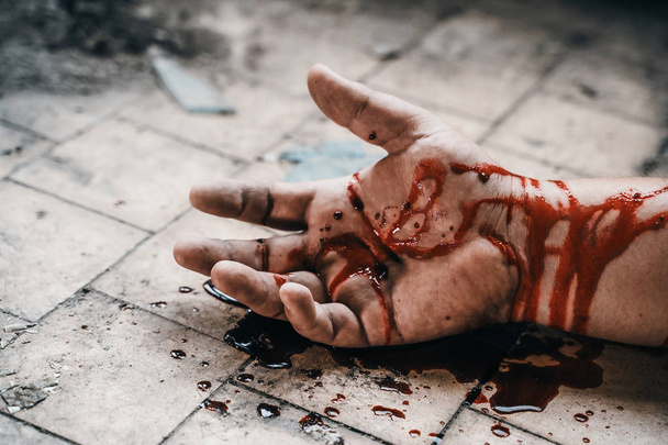 Cena de crime com mão humana em sangue no chão de homem morto por homicídio, parte de cadáver
 - Foto, Imagem