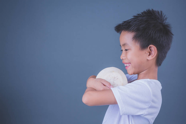 Children eat coconut water on a gray background. - Φωτογραφία, εικόνα