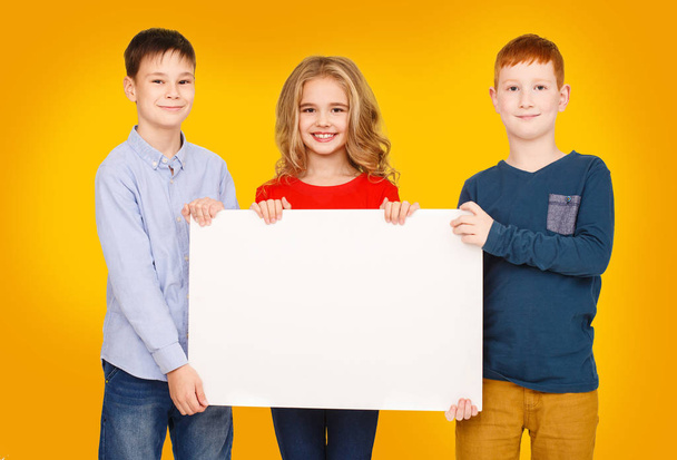 School children showing blank placard board for text - Fotoğraf, Görsel