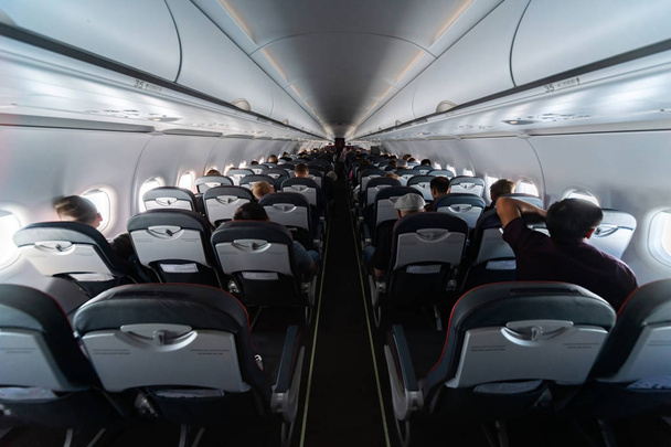 Asientos de cabina de avión con pasajeros. Clase económica de nuevo barato
 - Foto, Imagen