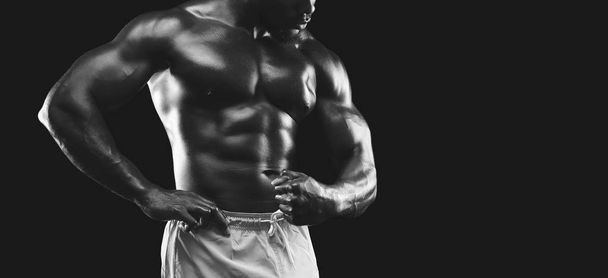 Braços musculares e tronco demonstrados pelo fisiculturista afro-americano
 - Foto, Imagem