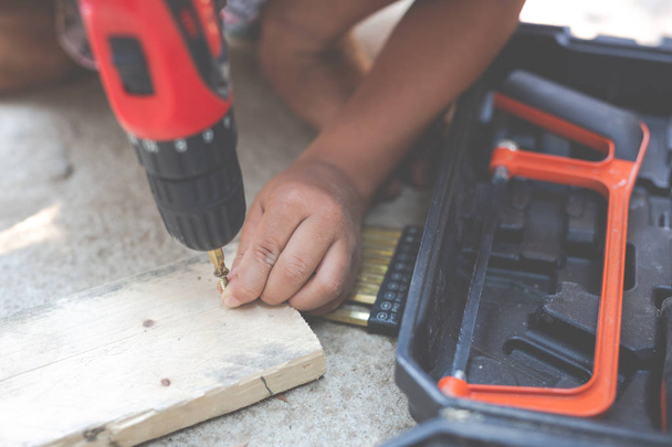 Boy child holding hand tools electric screwdriver. - Foto, imagen