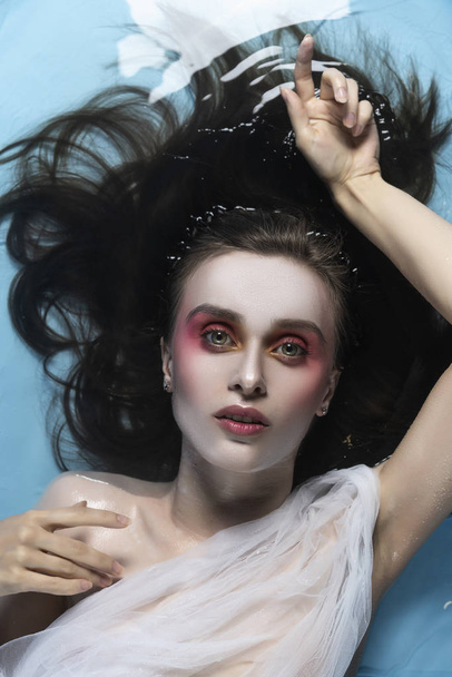 A beautiful naked girl with conceptual makeup in red tones - Valokuva, kuva