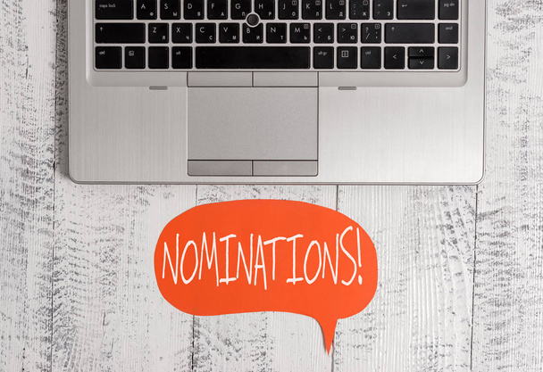 Writing note showing Nominations. Business photo showcasing action of nominating or state being nominated for prize Close view open laptop speech bubble downwards lying vintage table. - Photo, Image