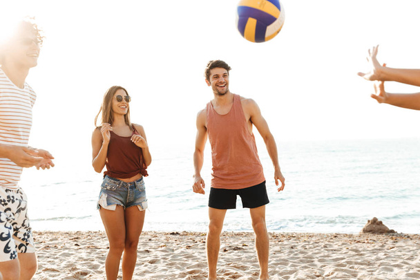 Group of cheerful friends playing volleyball - Foto, imagen