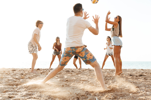 Groupe d'amis joyeux jouant au volleyball
 - Photo, image