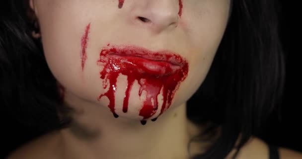 Bloody mouth and teeth of girl. Vampire Halloween makeup with dripping blood - Footage, Video