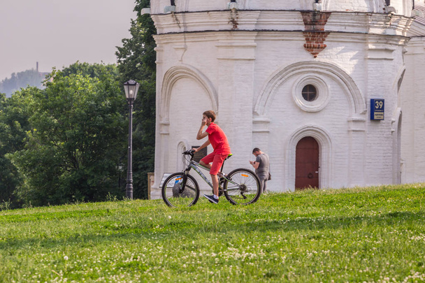 2019.05.31, Moskova, Rusya. Parkta tepeden aşağı bisikletle inen bir çocuk. Yaz aylarında çocukların aktif yaşam tarzı. - Fotoğraf, Görsel