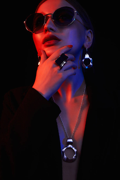 beautiful girl in sunglasses and jewelry.colorful lights - Foto, Imagem