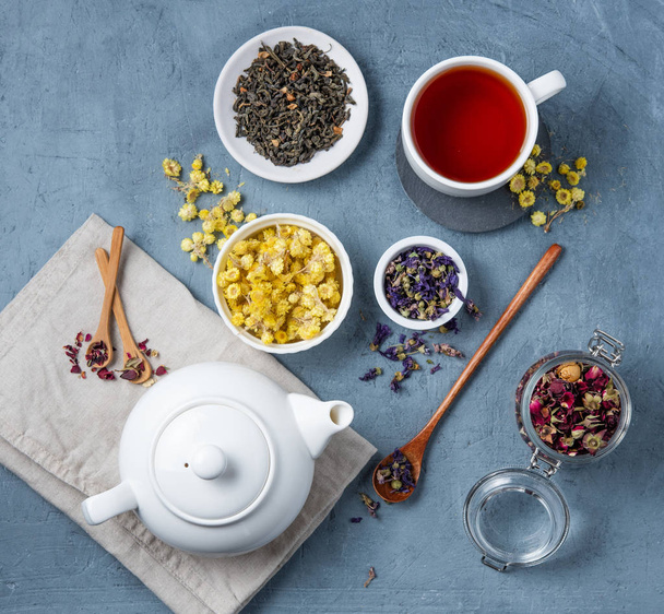 white teapot with cup of herbal tea lavender, chamomile and rose - Фото, зображення