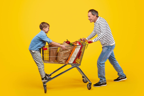 Father and son having fun in grocery store - Photo, image