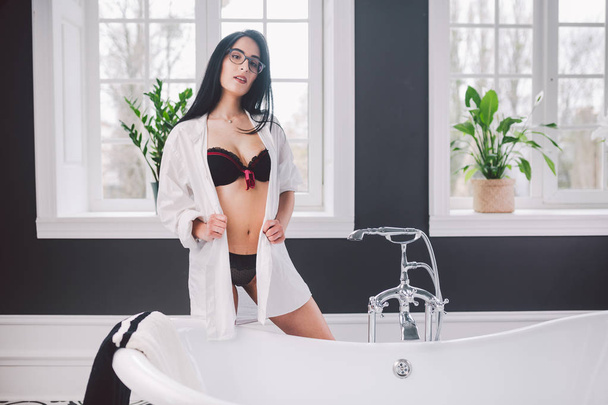 Kobieta w łazience. piękna dziewczyna na wannie w bieliźnie. Seks kobieta biorąc relaksujący kąpiel w jacuzzi. Piękna seksowna dama elegancka biała koszula w łazience. Moda model portret na kąpiel w pomieszczeniu - Zdjęcie, obraz