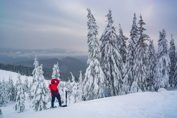 Photographer in a snowy winter valley - Foto, imagen
