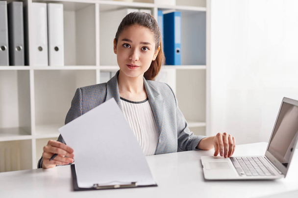 Young woman on first job in office - Foto, Imagen
