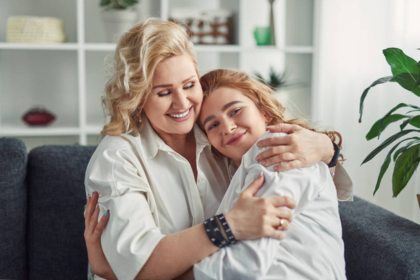 Mother hugging daughter at home - Φωτογραφία, εικόνα