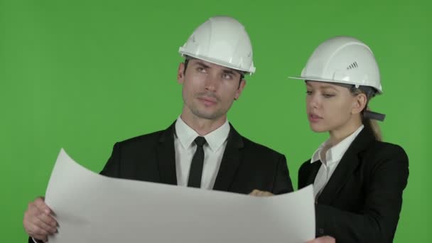 Tevreden mannelijke en vrouwelijke ingenieurs die bouw blauwdruk bestuderen, Chroma Key - Video