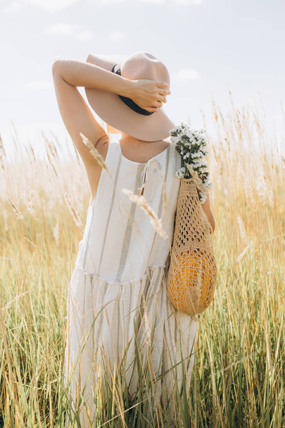 woman natural clothes eco mesh string bag wildflowers - Foto, afbeelding