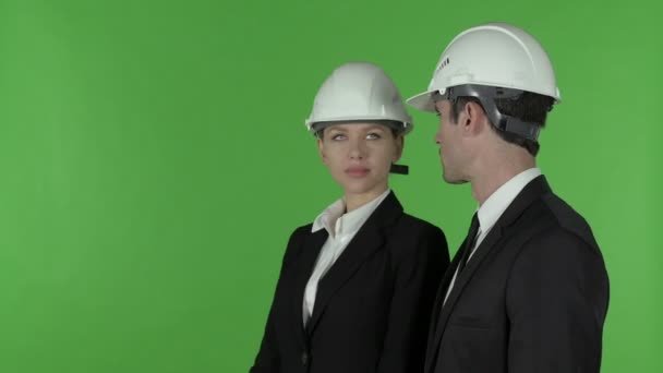 Πλευρική όψη του θηλυκού μηχανικού κατασκευών που δείχνει ότι στέκεται με αρσενικό μηχανικό, πλήκτρο αποχρώσεων - Πλάνα, βίντεο