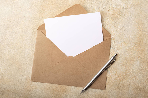 Blank paper in Kraft envelope on a light background. Clean postcard for your signatures. Top view - Fotografie, Obrázek