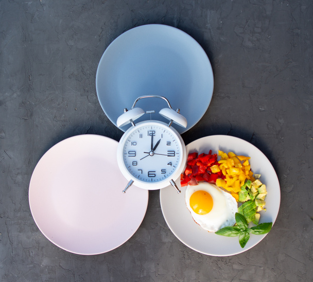 空のカラフルなプレートと断続的な断食の概念。体重を減らす時間、食事のコントロールやダイエットの概念への時間. - 写真・画像
