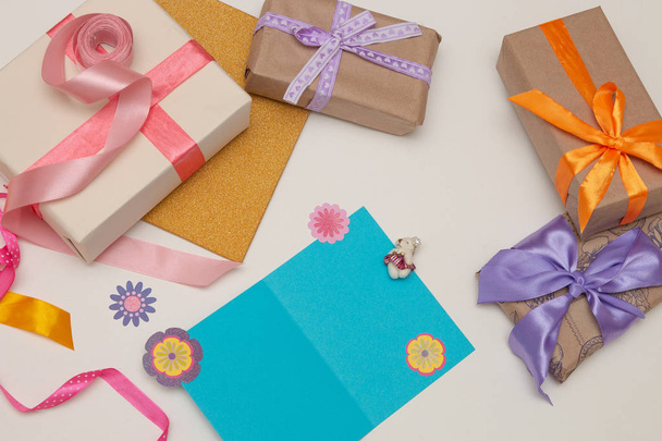 gifts boxes with bright ribbons and bows on a white background blue postcard, money, dollar bills, euros, copy place, top view, birthday, Thanksgiving, holiday, new year, christmas, flat lay - Φωτογραφία, εικόνα