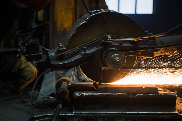 Sparks from circular saw at steel factory. Metal sawing close up. - 写真・画像