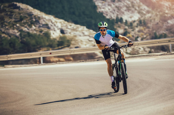Férfi lovagolni Mountain Bike az úton. Sport-és aktív élet fogalmi - Fotó, kép