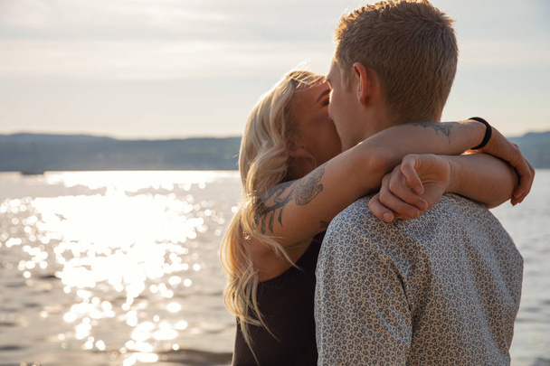 夏のビーチでロマンチックな抱擁でカップルのキス - 写真・画像