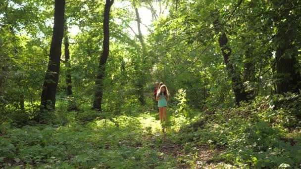apa és lánya, a gyermekek utazási parkban nyáron. Családi nyaraláson utazik az erdőben. barátok-turisták megy kemping az erdőben. Az emberek séta a fák és a fű. csapatmunka utazóknak - Felvétel, videó