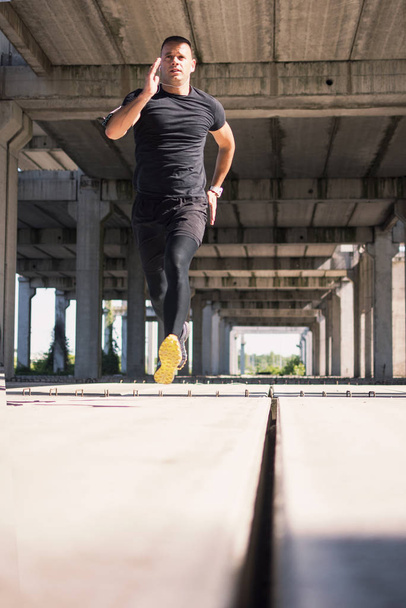 A sportsman on the sprint training at the unfinished building. - Fotoğraf, Görsel