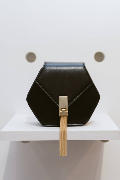 Musta klassinen nahka laukku kulta lukko hyllyllä myymälässä. Tyylikäs rento naisten laukku
 - Valokuva, kuva