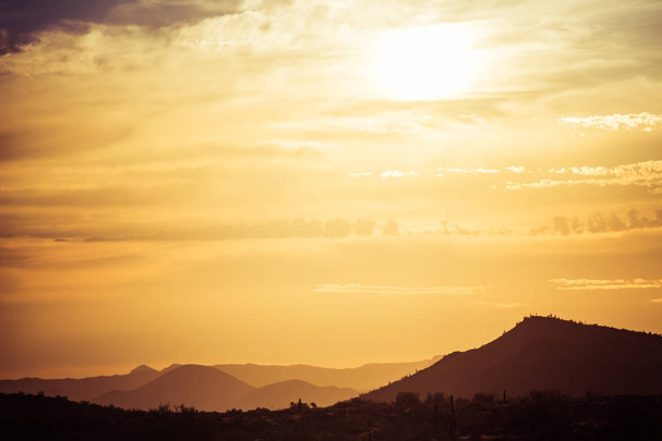 A sunset over a distant mountain - Foto, immagini
