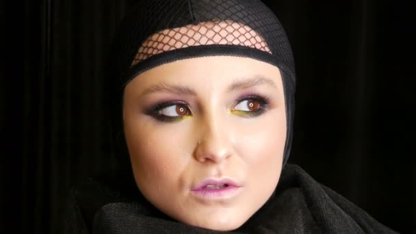 Professional tyttö malli kaunis meikki poseeraa musta lippis päähänsä kameran edessä mustalla taustalla kuvan musta leski. Huippumuoti
 - Materiaali, video