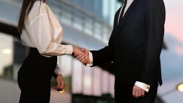 Handshake tussen business man en Business vrouw buitenshuis door Business Building. - Video