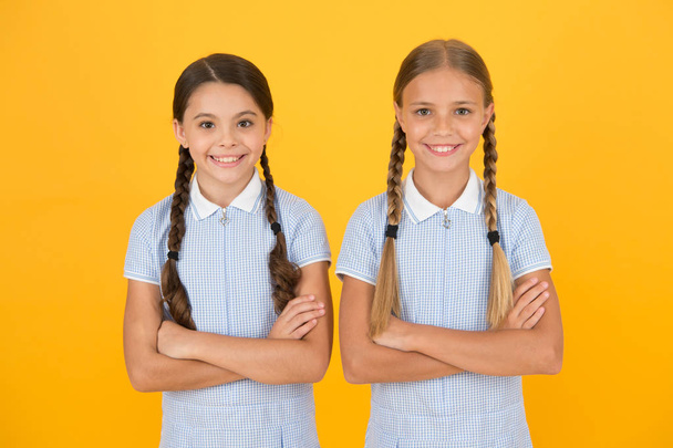 school authority. happy girls with pigtails. happy childhood. brunette and blond hair. best friends. vintage style. small confident girls in retro uniform. old school fashion. back to school - Foto, Bild
