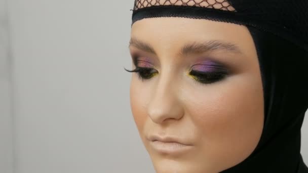 Profesjonalny Model Dziewczyna z pięknym makijażu stwarza w czarnej czapce na głowie w obrazie czarnej wdowy. Wysoka moda - Materiał filmowy, wideo